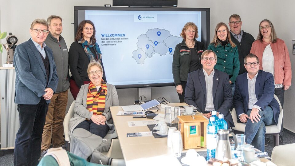 Gruppenbild der beteiligten Industriekultur-Macher vor einem Bildschirm mit den virtuellen Welten