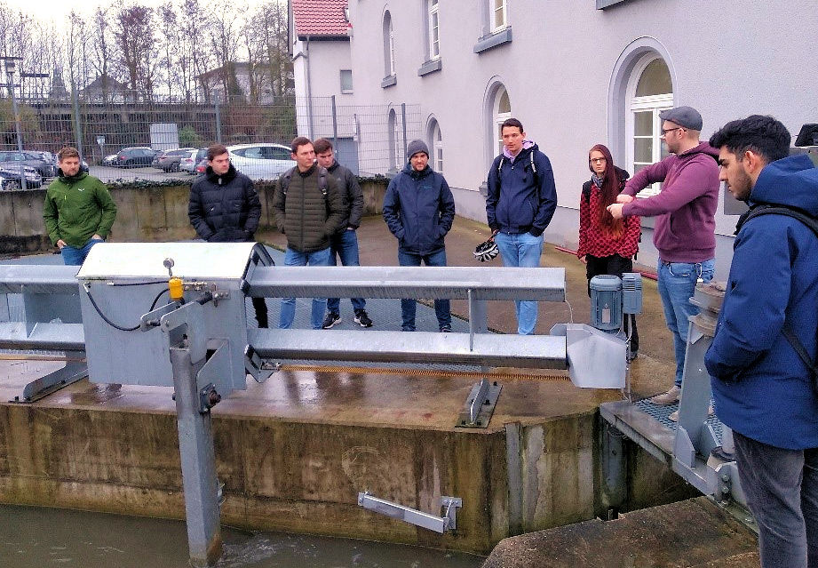 Anlagenbetreiber Eduard Windmeier erläutert den Gästen von der THM an der Klinkel'schen Mühle den Wasserzufluss zur Turbine und den gerade aktiven Rechenreiniger (Foto: Technische Hochschule Mittelhessen)